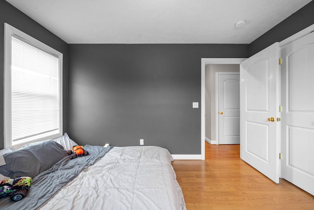 bedroom with multiple windows and light wood-type flooring