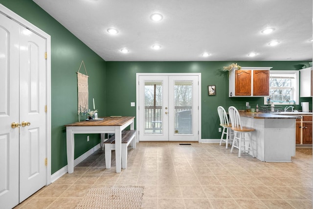 kitchen with sink, a kitchen breakfast bar, french doors, and kitchen peninsula