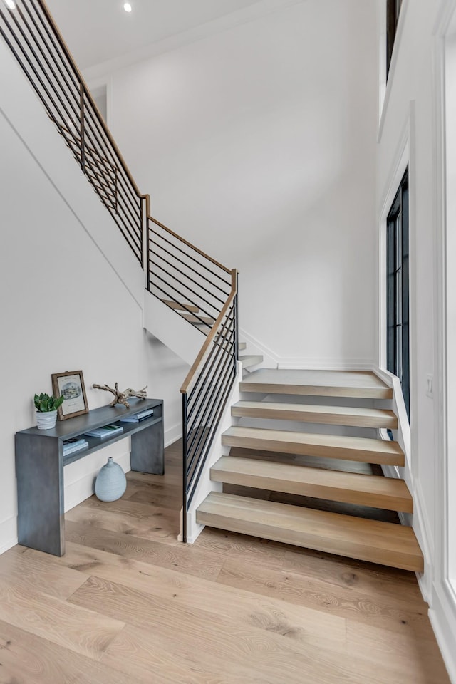 staircase featuring hardwood / wood-style floors and a high ceiling