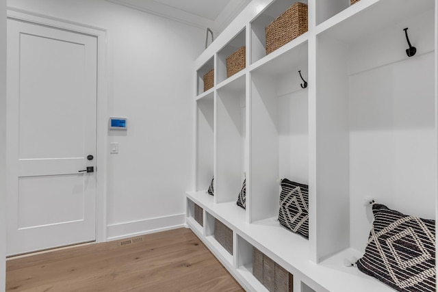 mudroom featuring crown molding and light hardwood / wood-style floors