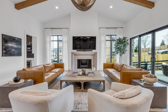 living room featuring beamed ceiling, a wealth of natural light, and high vaulted ceiling