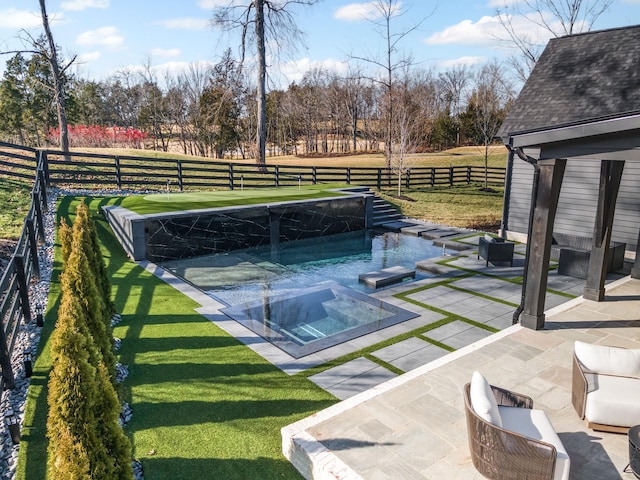 view of pool with a rural view, a yard, a patio area, and an in ground hot tub