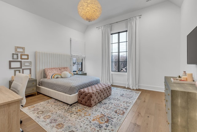 bedroom featuring lofted ceiling and light hardwood / wood-style floors