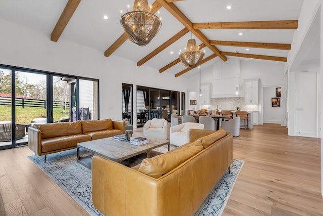 living room with an inviting chandelier, light hardwood / wood-style floors, high vaulted ceiling, and beamed ceiling