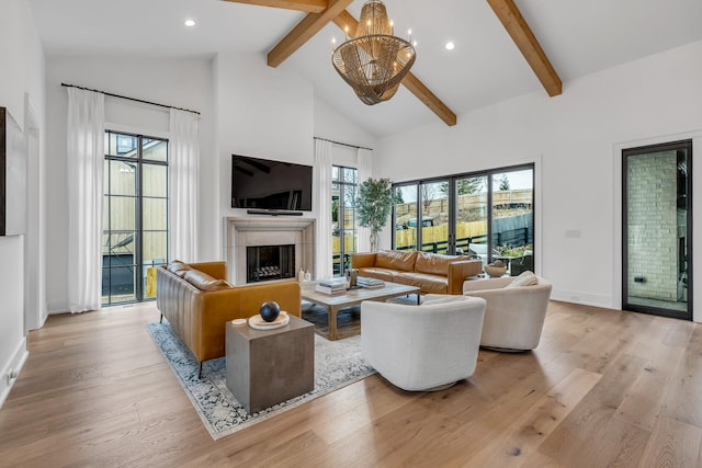 living room with beam ceiling, high vaulted ceiling, and light hardwood / wood-style flooring