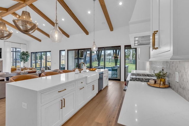 kitchen with a large island, sink, hanging light fixtures, and white cabinets