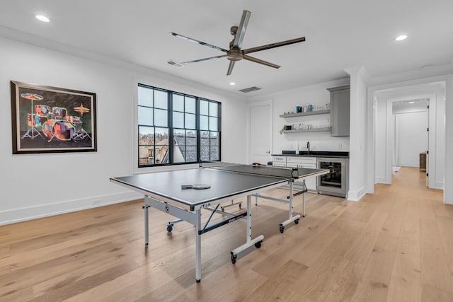 playroom featuring wine cooler, ceiling fan, indoor wet bar, and light hardwood / wood-style flooring