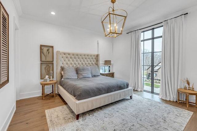 bedroom featuring access to outside, a chandelier, and light wood-type flooring