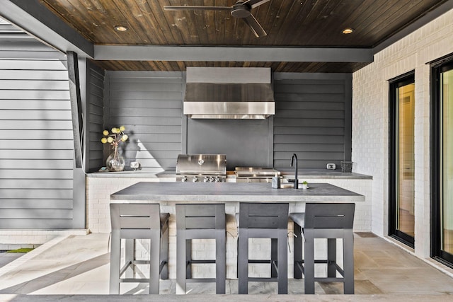 view of patio with grilling area, an outdoor kitchen, ceiling fan, and an outdoor wet bar