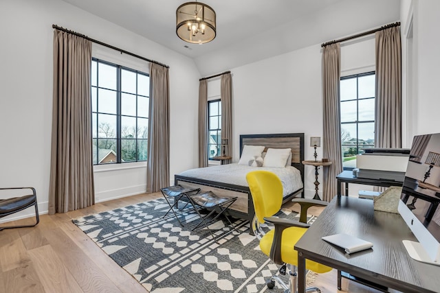 bedroom with a notable chandelier and light hardwood / wood-style flooring