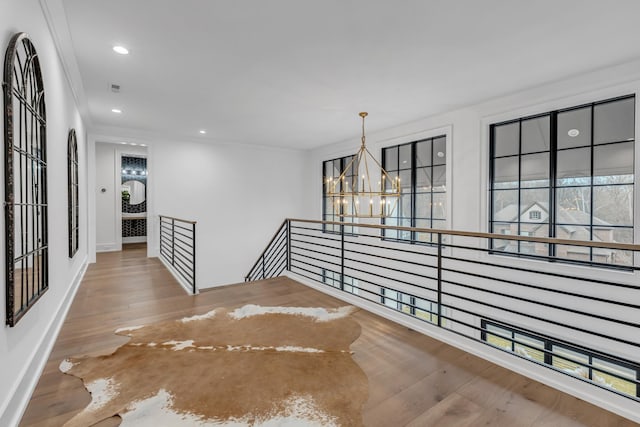 interior space featuring a notable chandelier, crown molding, and hardwood / wood-style floors