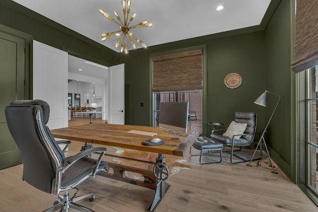 home office featuring crown molding, a notable chandelier, and light wood-type flooring