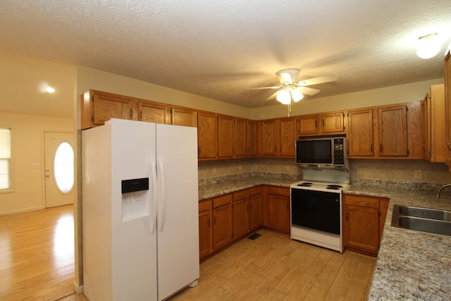 kitchen featuring sink, white appliances, ceiling fan, tasteful backsplash, and light hardwood / wood-style floors