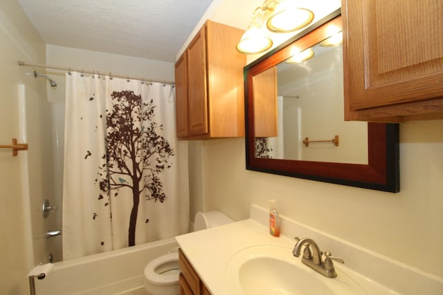 full bathroom with shower / bath combination with curtain, vanity, toilet, and a textured ceiling