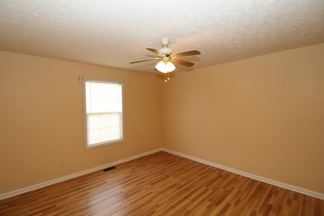 unfurnished room with ceiling fan, hardwood / wood-style flooring, and a textured ceiling