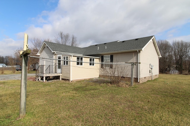 rear view of house with a wooden deck and a lawn