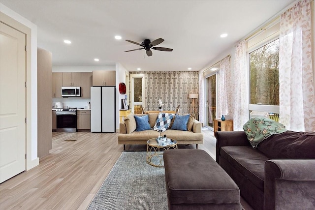 living room featuring a ceiling fan, light wood-style flooring, and recessed lighting