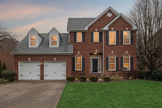 view of front of property with a garage and a lawn