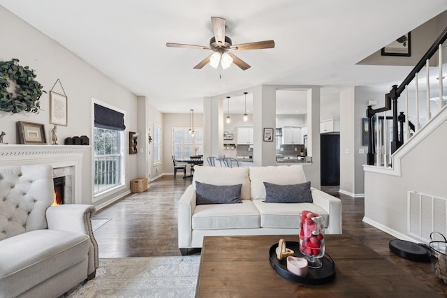 living room with ceiling fan, dark hardwood / wood-style floors, and a fireplace