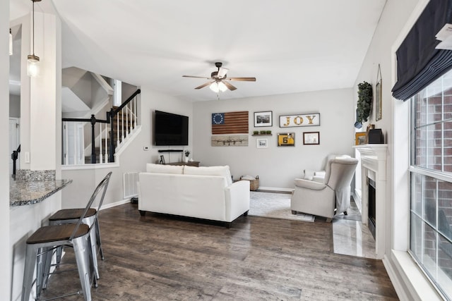 living room with dark hardwood / wood-style flooring and ceiling fan