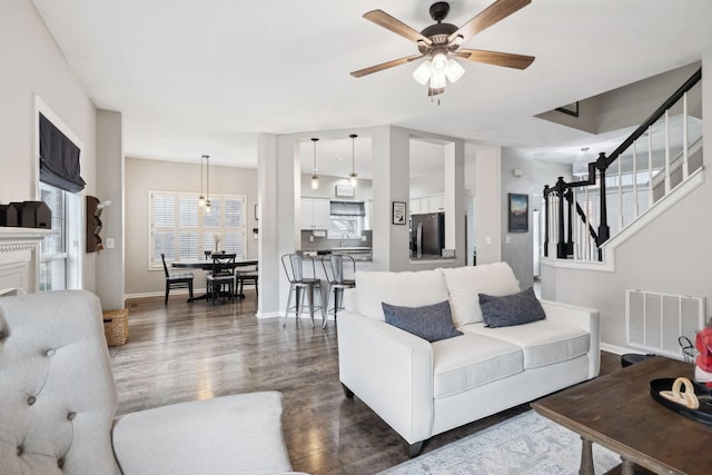 living room with ceiling fan, dark hardwood / wood-style flooring, and sink