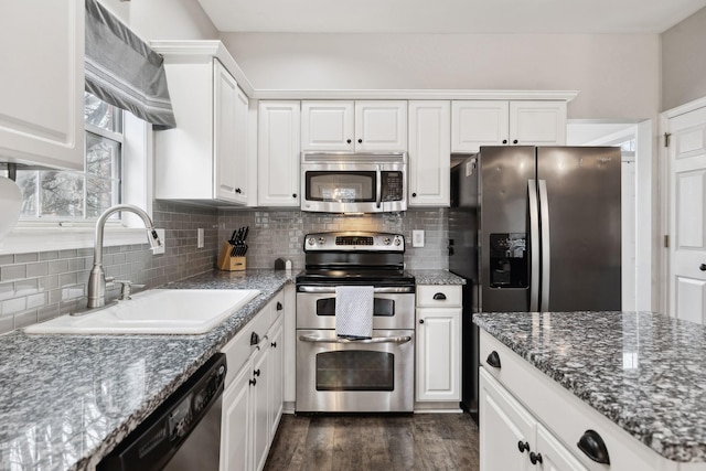 kitchen with stainless steel appliances, sink, white cabinets, and decorative backsplash