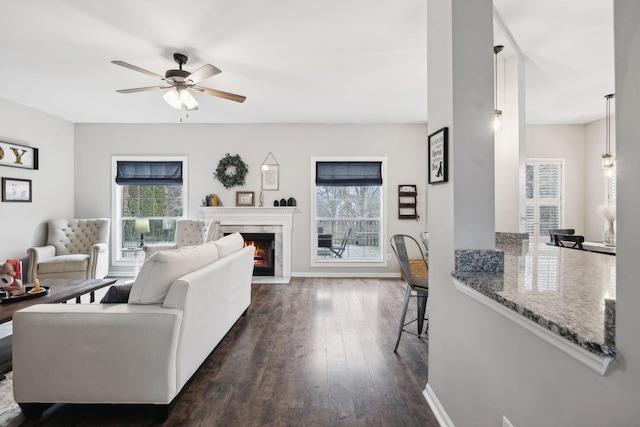 living room with a fireplace, dark hardwood / wood-style floors, and ceiling fan