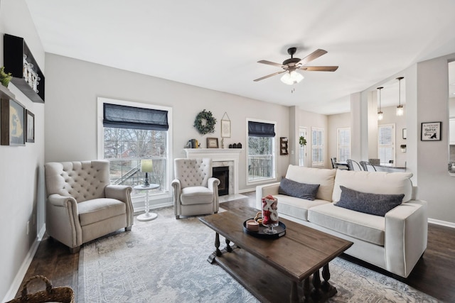 living room with ceiling fan, plenty of natural light, and dark hardwood / wood-style flooring