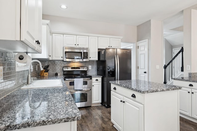 kitchen featuring a kitchen island, white cabinetry, appliances with stainless steel finishes, and sink