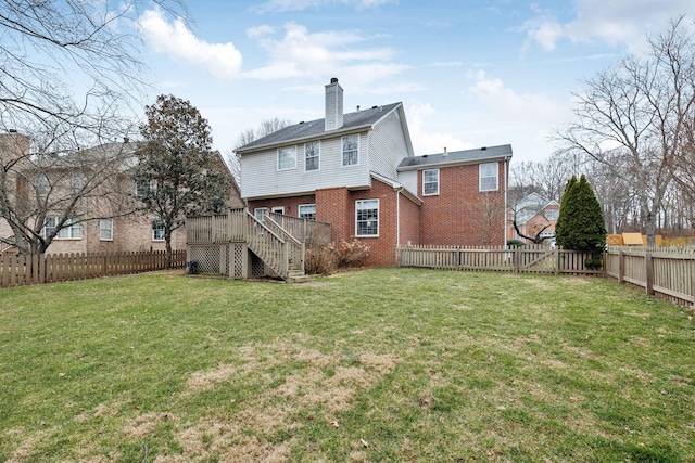 rear view of property with a wooden deck and a yard