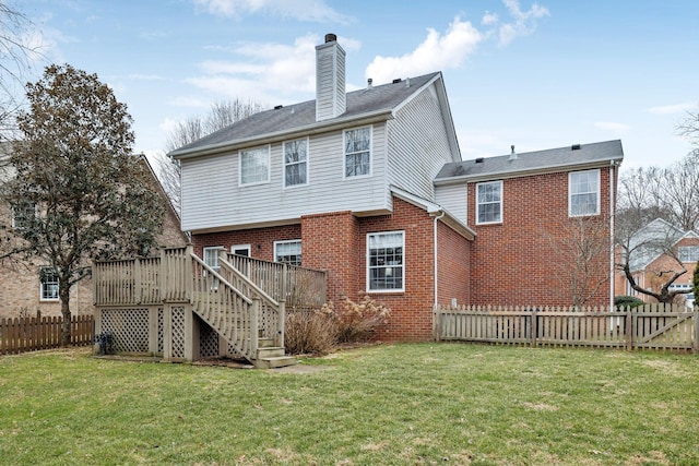 rear view of house featuring a wooden deck and a yard