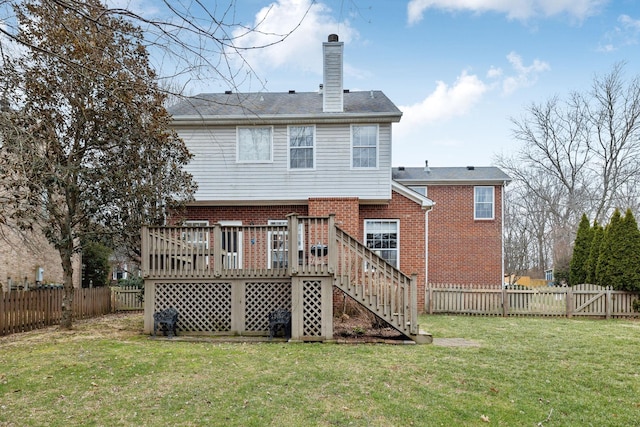 back of house featuring a lawn and a deck