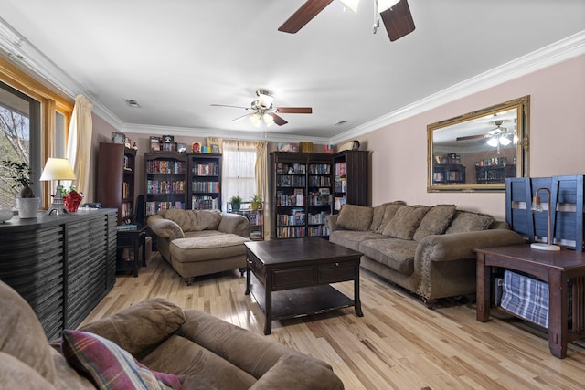 living room with ornamental molding, ceiling fan, and light wood-type flooring