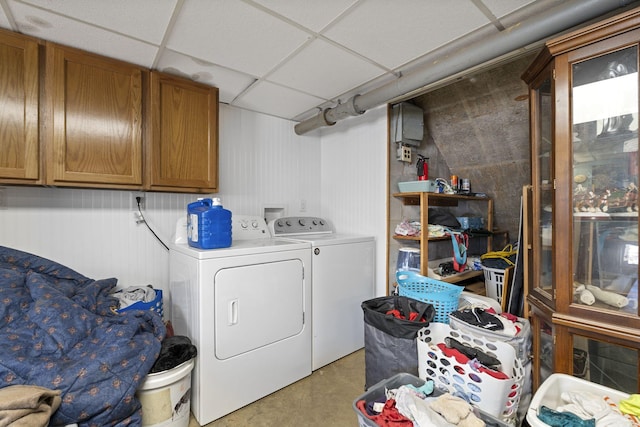 clothes washing area featuring independent washer and dryer and cabinets