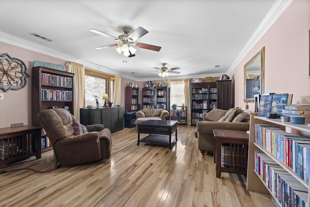 living room with crown molding, ceiling fan, and light wood-type flooring