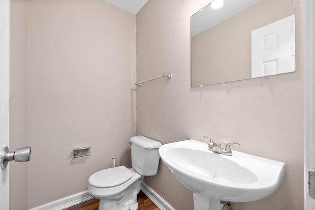 bathroom with sink, hardwood / wood-style floors, and toilet