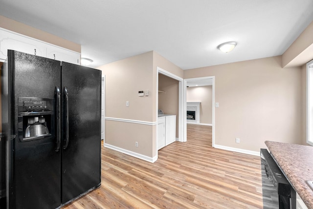 kitchen featuring white cabinetry, light wood-type flooring, and black appliances