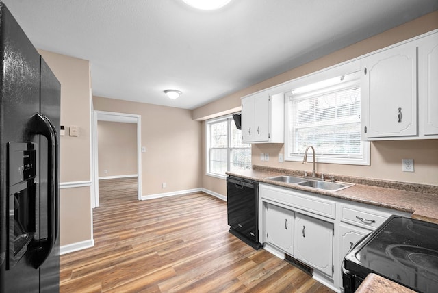 kitchen with white cabinetry, light wood-type flooring, sink, and black appliances