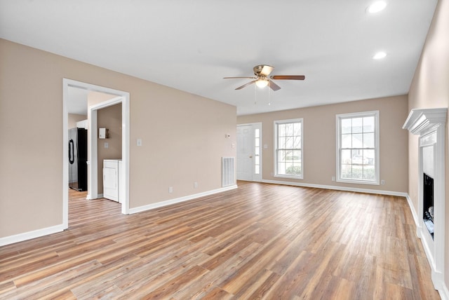 unfurnished living room with ceiling fan and light hardwood / wood-style flooring