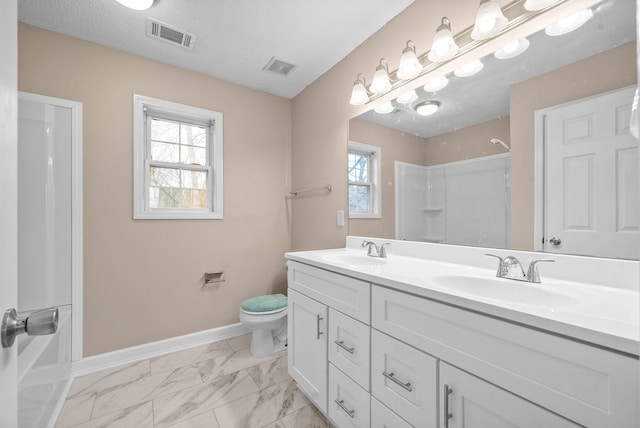 bathroom with vanity, toilet, a textured ceiling, and a shower