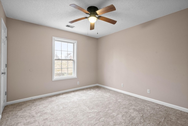 empty room with ceiling fan, a textured ceiling, and carpet