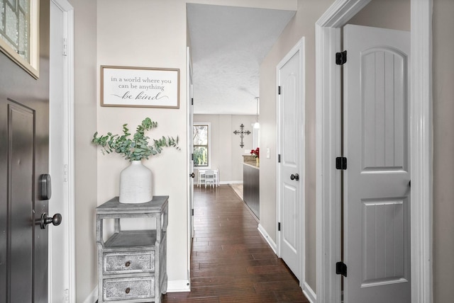 hallway featuring a textured ceiling and dark hardwood / wood-style flooring