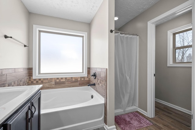 bathroom featuring vanity, wood-type flooring, independent shower and bath, and a textured ceiling