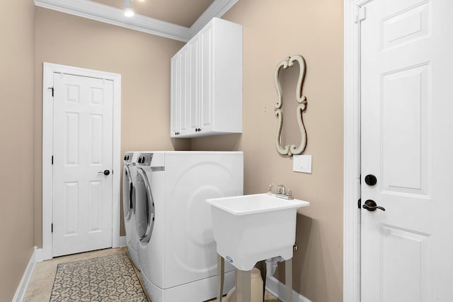 laundry room featuring cabinets, ornamental molding, washer and clothes dryer, and sink