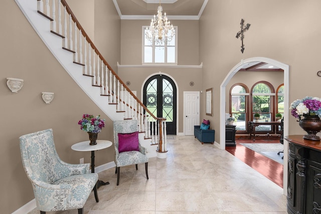 foyer featuring ornamental molding, a chandelier, and a high ceiling