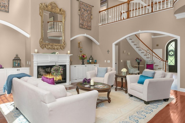 living room with hardwood / wood-style flooring and a towering ceiling