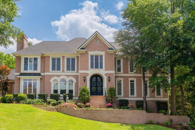 view of front of home with a front yard and french doors