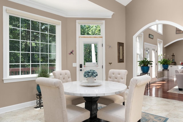 dining room featuring a towering ceiling and ornamental molding