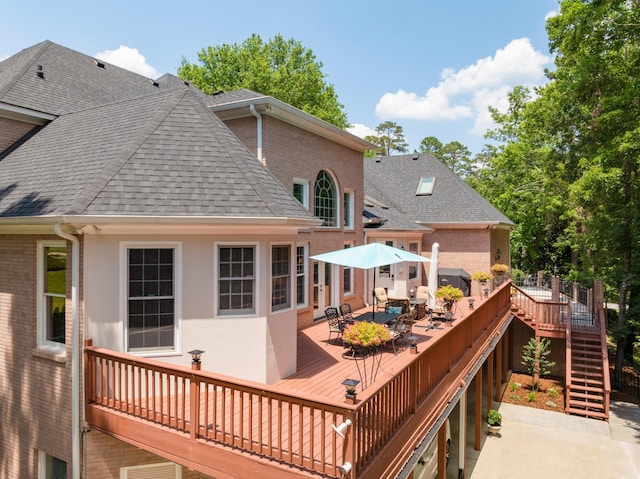 wooden terrace featuring area for grilling and a patio