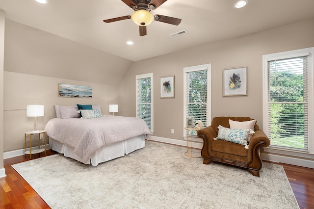 bedroom featuring multiple windows, light hardwood / wood-style floors, and lofted ceiling